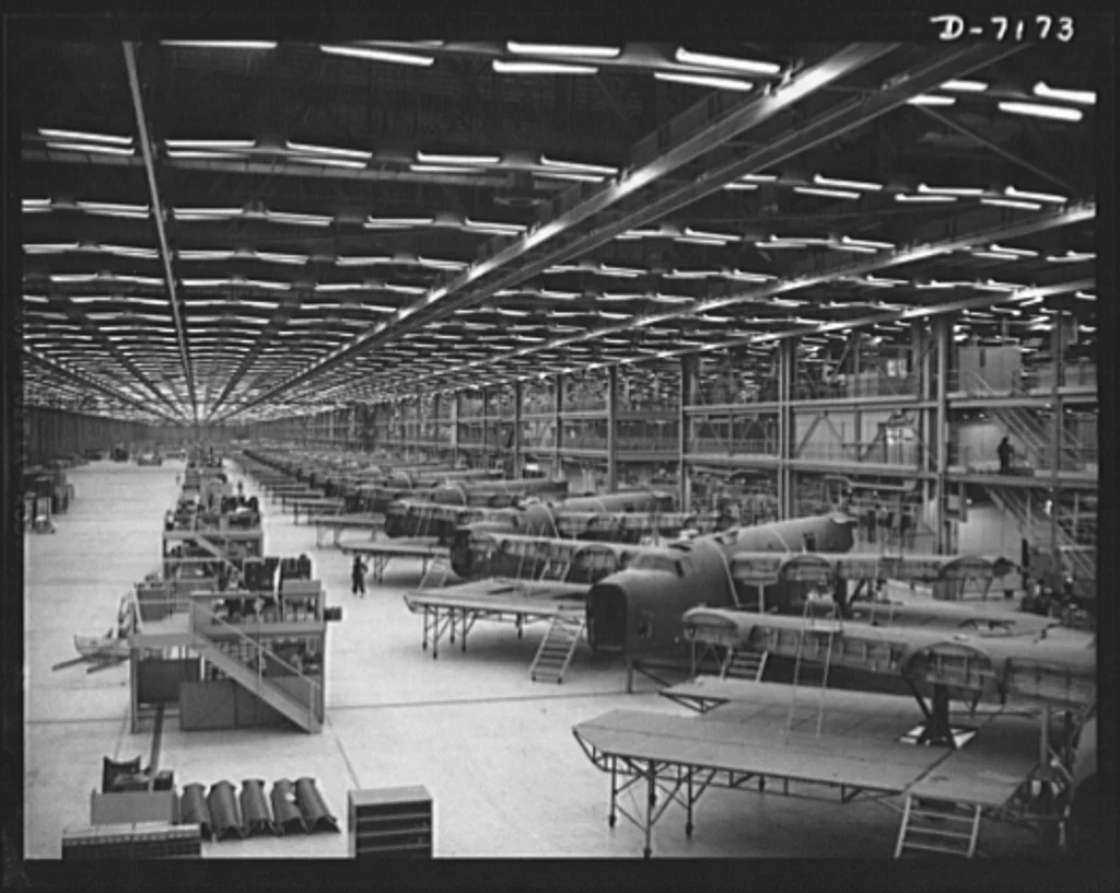 Production. B-24 bombers and C-87 transports. Half down the final line of a Western aircraft plant at which consolidated B-24 bombers and transports are made. This new transports, an adaptation of the B-24 bomber, is known as the C-87 and carries one of the greatest human or cargo loads of any plane now in mass production. It is built in a plant equipped with one of the best air conditioning and fluorescent lighting systems in the country.

An aircraft plant. Source:  GetArchive